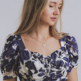 model displaying gold-filled and gemstone mermaid and opal charm necklace