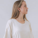 model wearing sand + salt jewelry; gold-filled, gemstone, and freshwater pearl jewelry