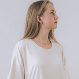 model wearing sand + salt jewelry; gold-filled, gemstone, and freshwater pearl jewelry
