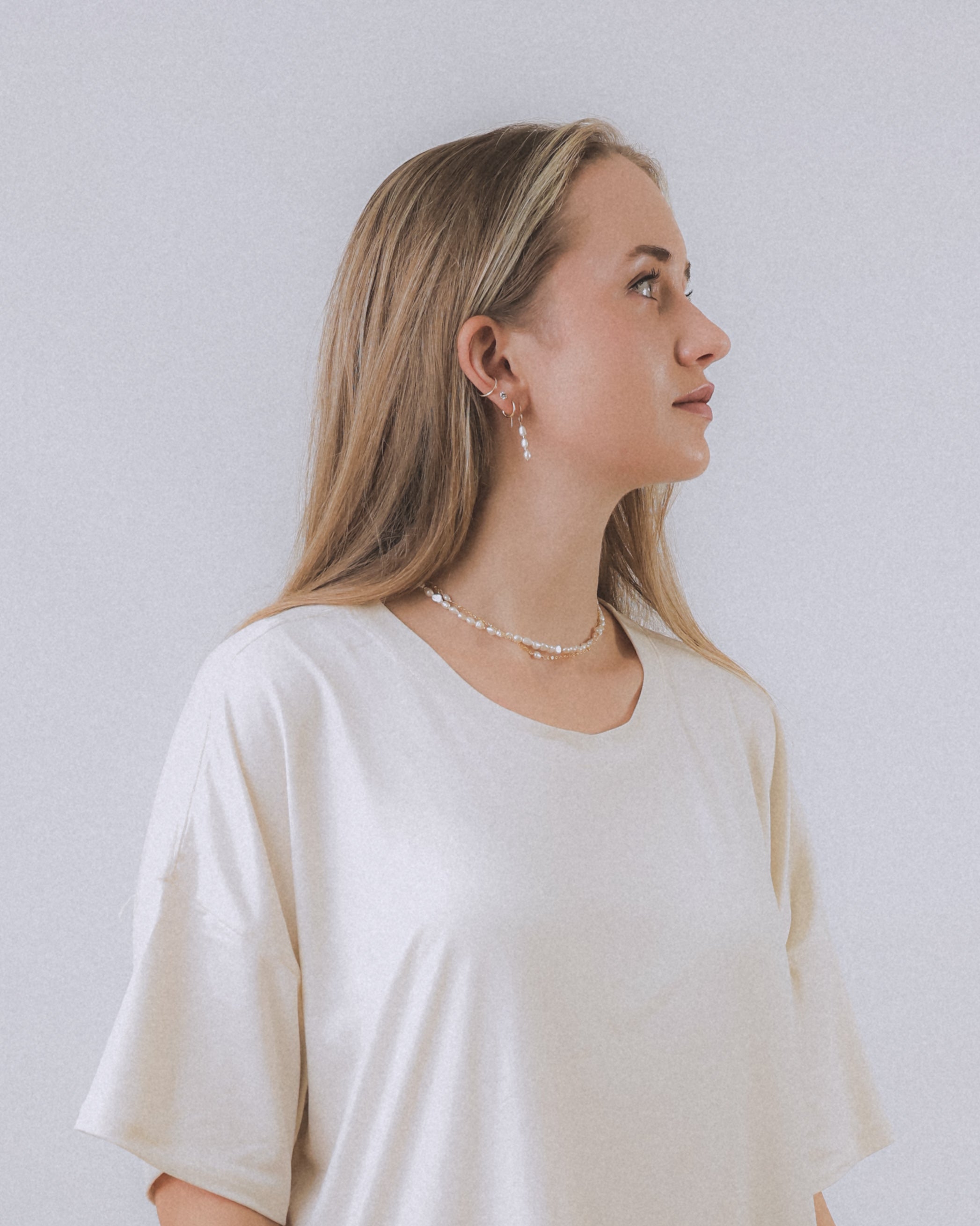 model wearing sand + salt jewelry; gold-filled, gemstone, and freshwater pearl jewelry