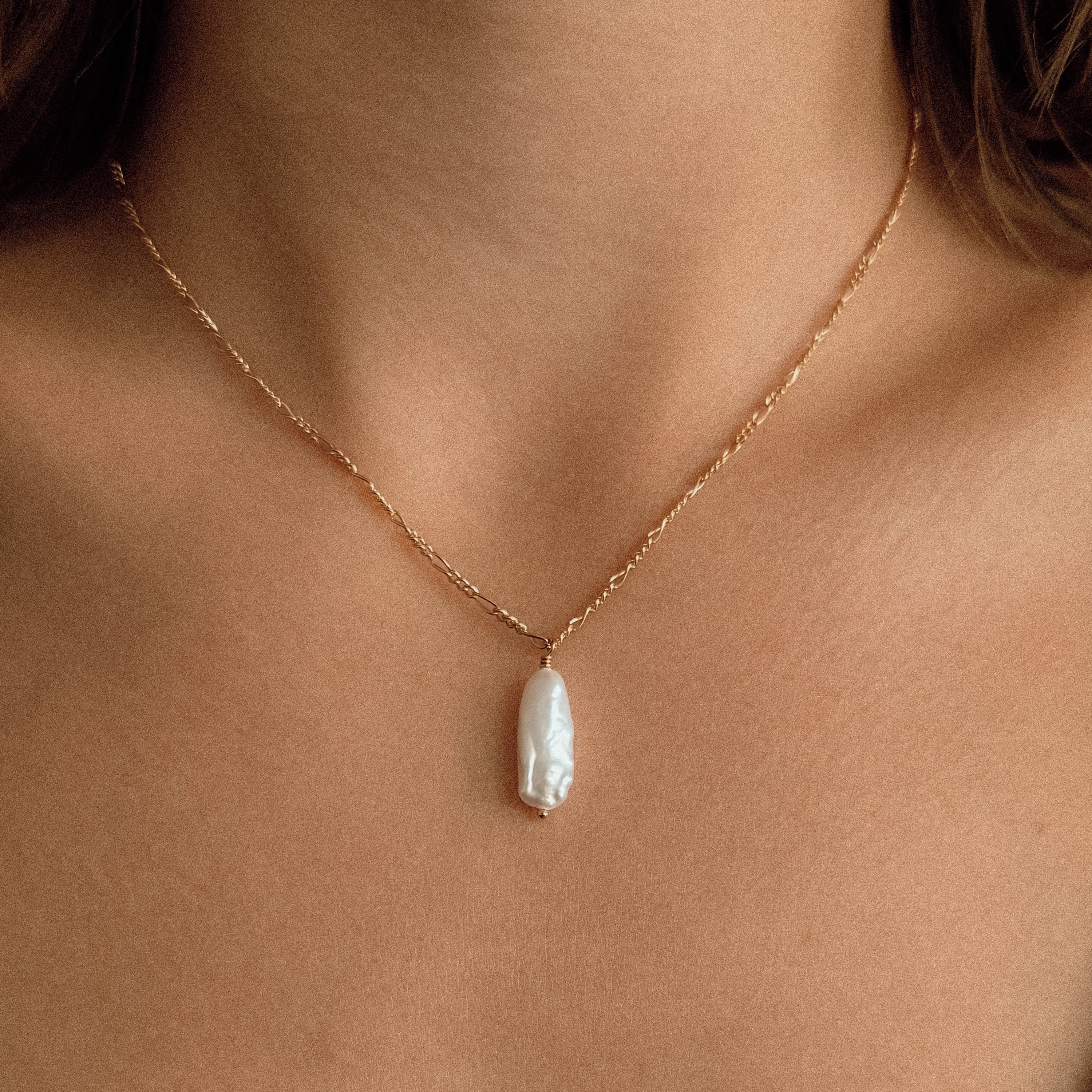 Sand + Salt Studio / close-up of woman's neck wearing necklaces from Sand and Salt Studio collections
