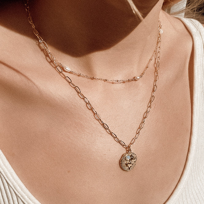 Sand + Salt Studio / close-up of woman's neck wearing necklaces from Sand and Salt Studio collections
