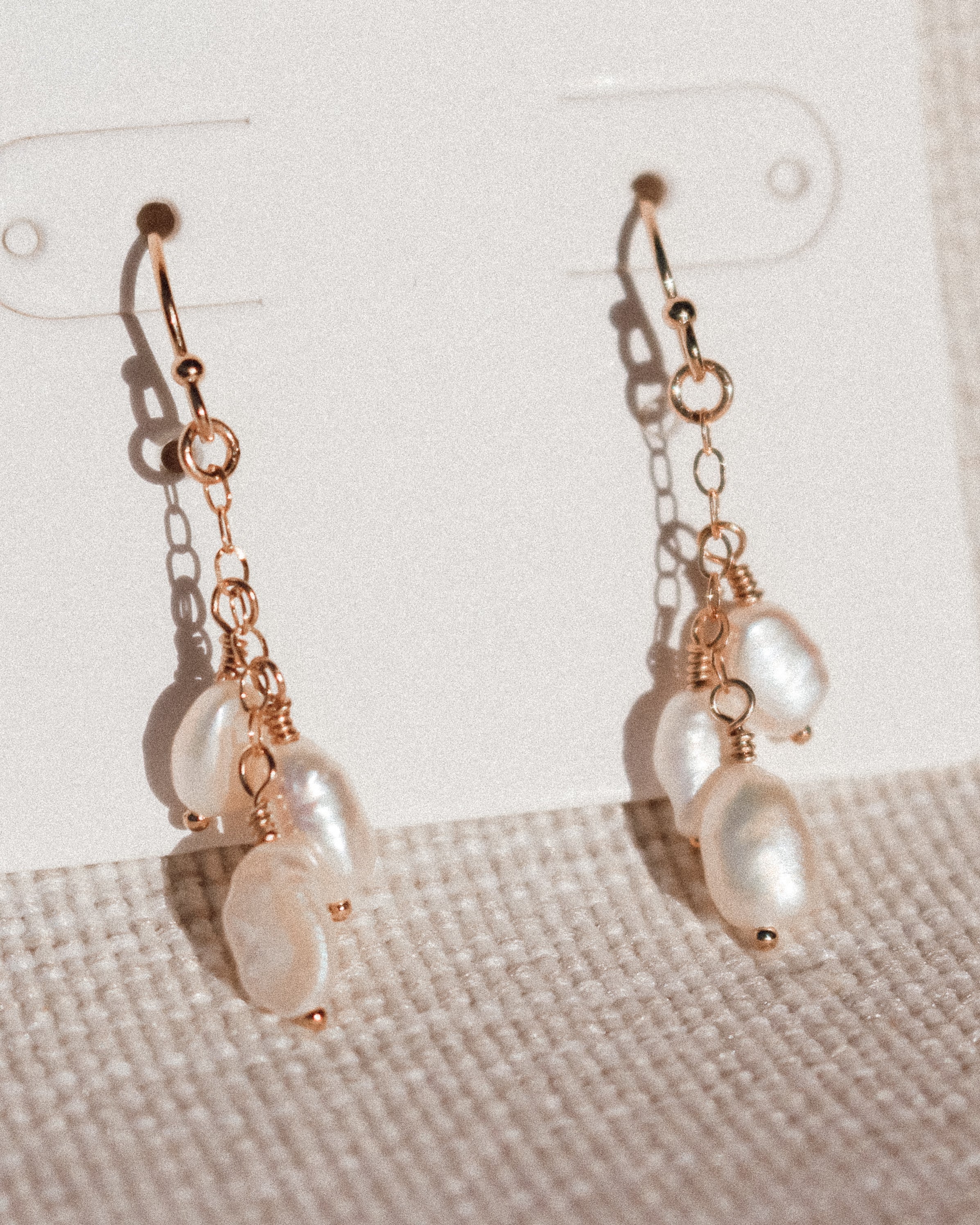 Sand + Salt Pearl pendant, 14k gold-filled necklace.  Hanging in front of an ocean backdrop. Sand + Salt Studio / Sand and Salt Studio