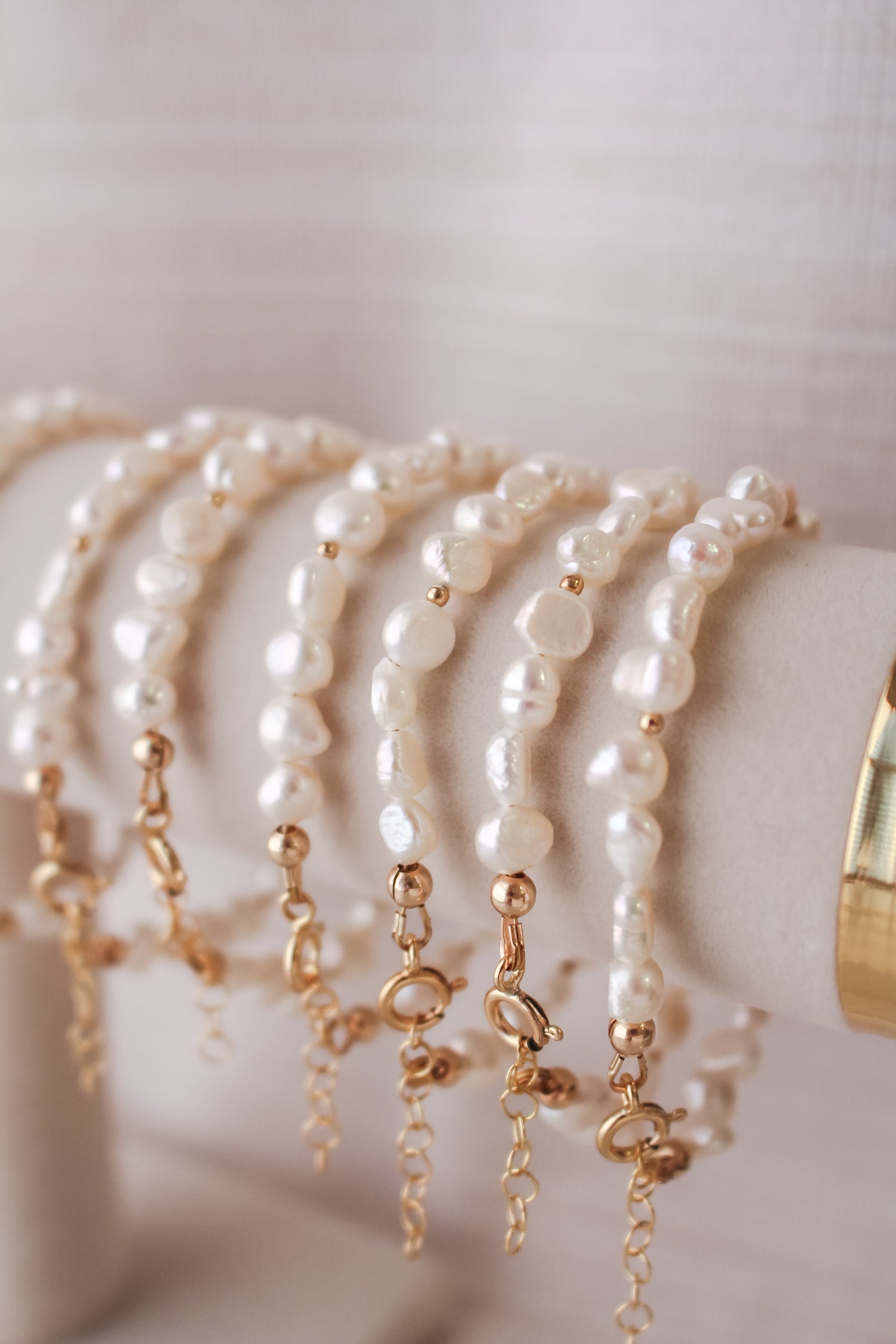 Sand + Salt Pearl pendant, 14k gold-filled necklace.  Hanging in front of an ocean backdrop. Sand + Salt Studio / Sand and Salt Studio