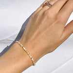 mother of pearl beaded bracelet modeled on wrist; gold-filled and gemstone jewelry sand + salt