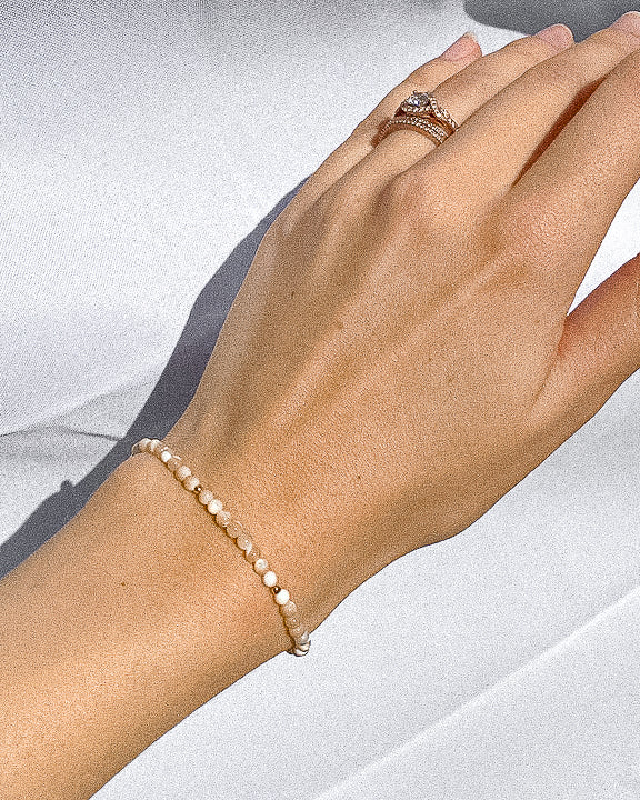 mother of pearl beaded bracelet modeled on wrist; gold-filled and gemstone jewelry sand + salt