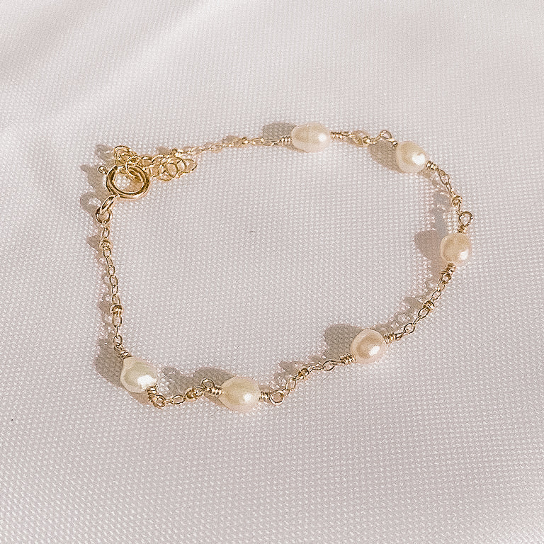 pearlfect bracelet in the sunlight on a white cloth background, gold filled and freshwater pearl jewelry