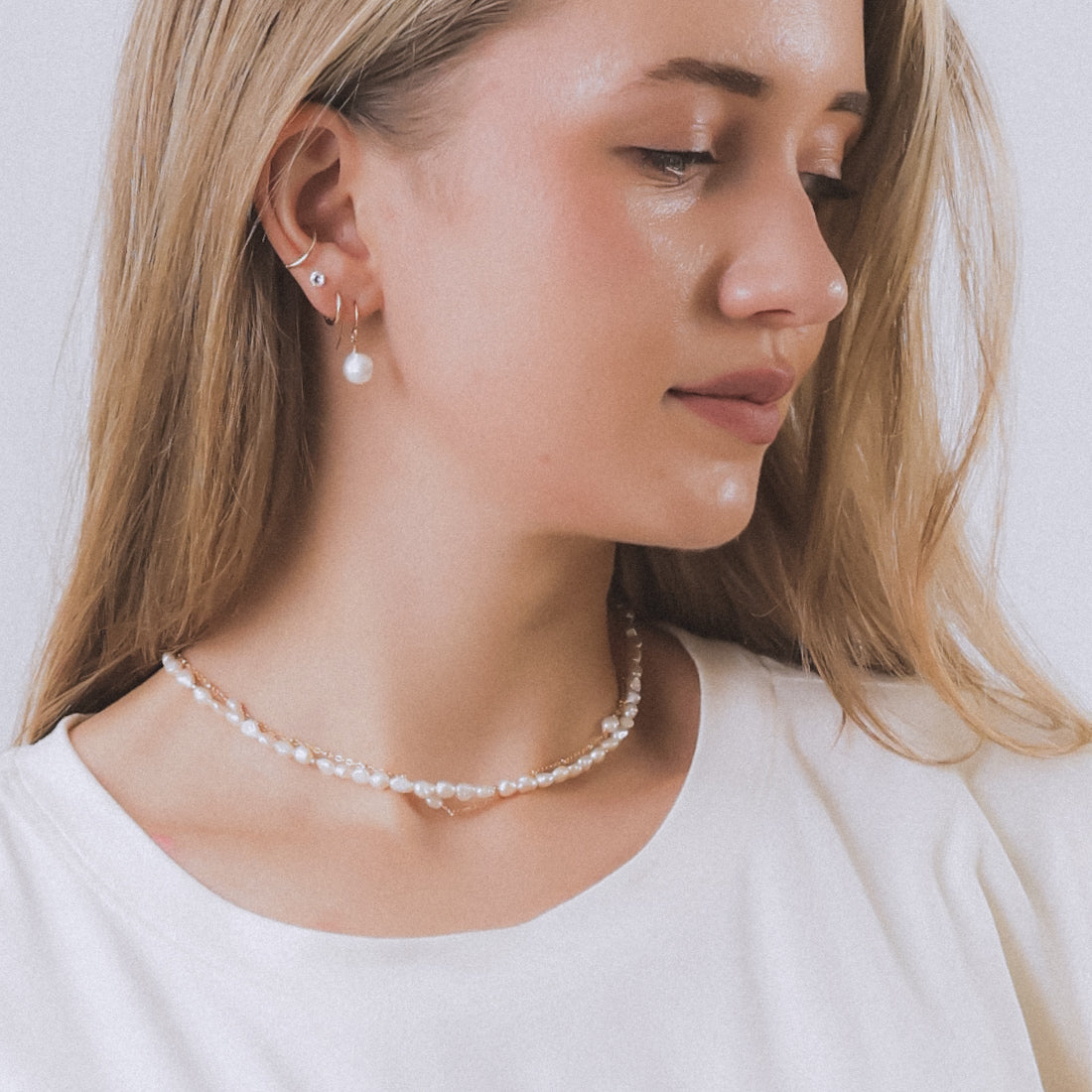 model wearing sand + salt jewelry; gold-filled, gemstone, and freshwater pearl jewelry
