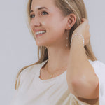 model wearing sand + salt jewelry; gold-filled, gemstone, and freshwater pearl jewelry