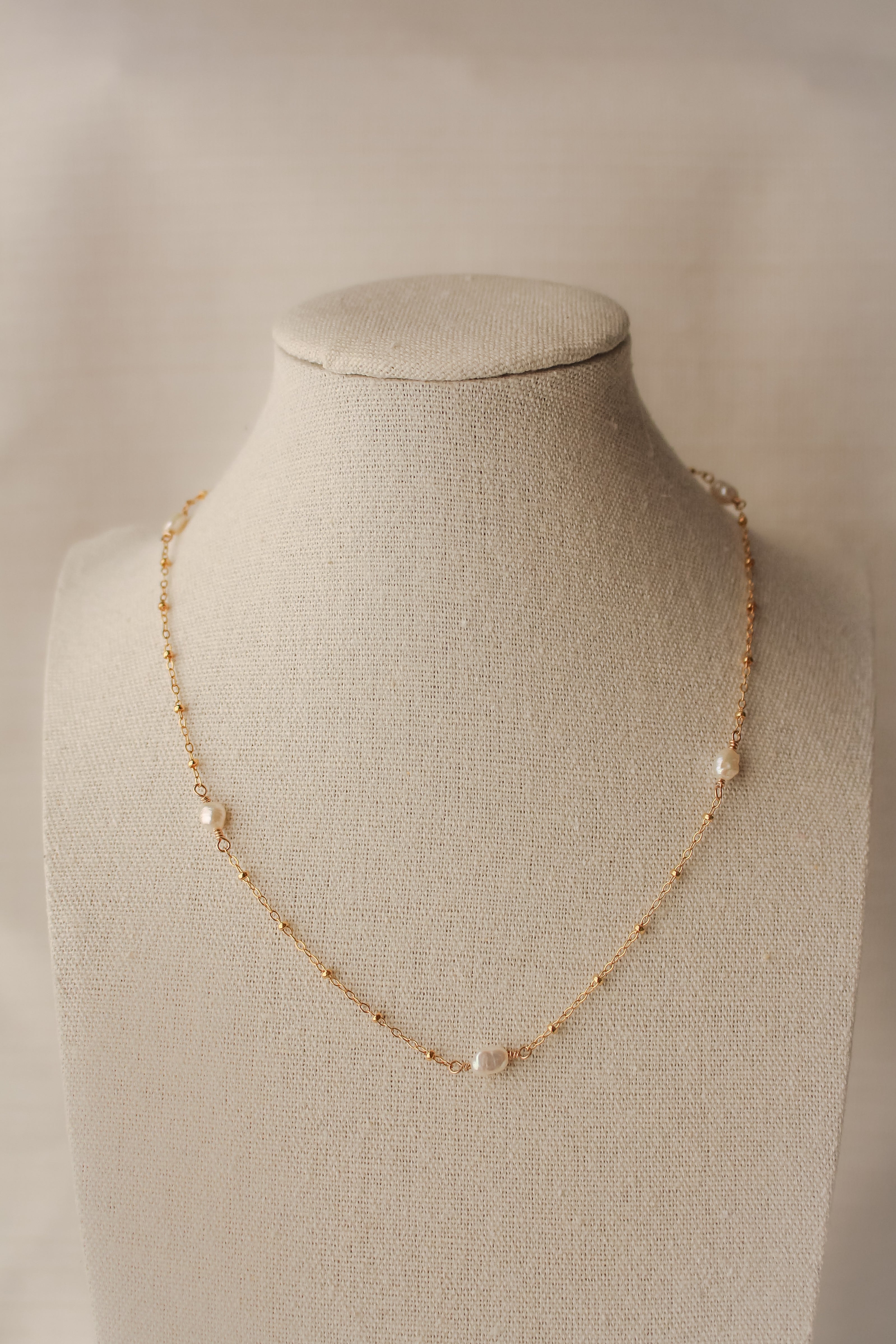 sand + salt pearlfect necklace on jewelry display bust, gold-filled and freshwater pearl necklace